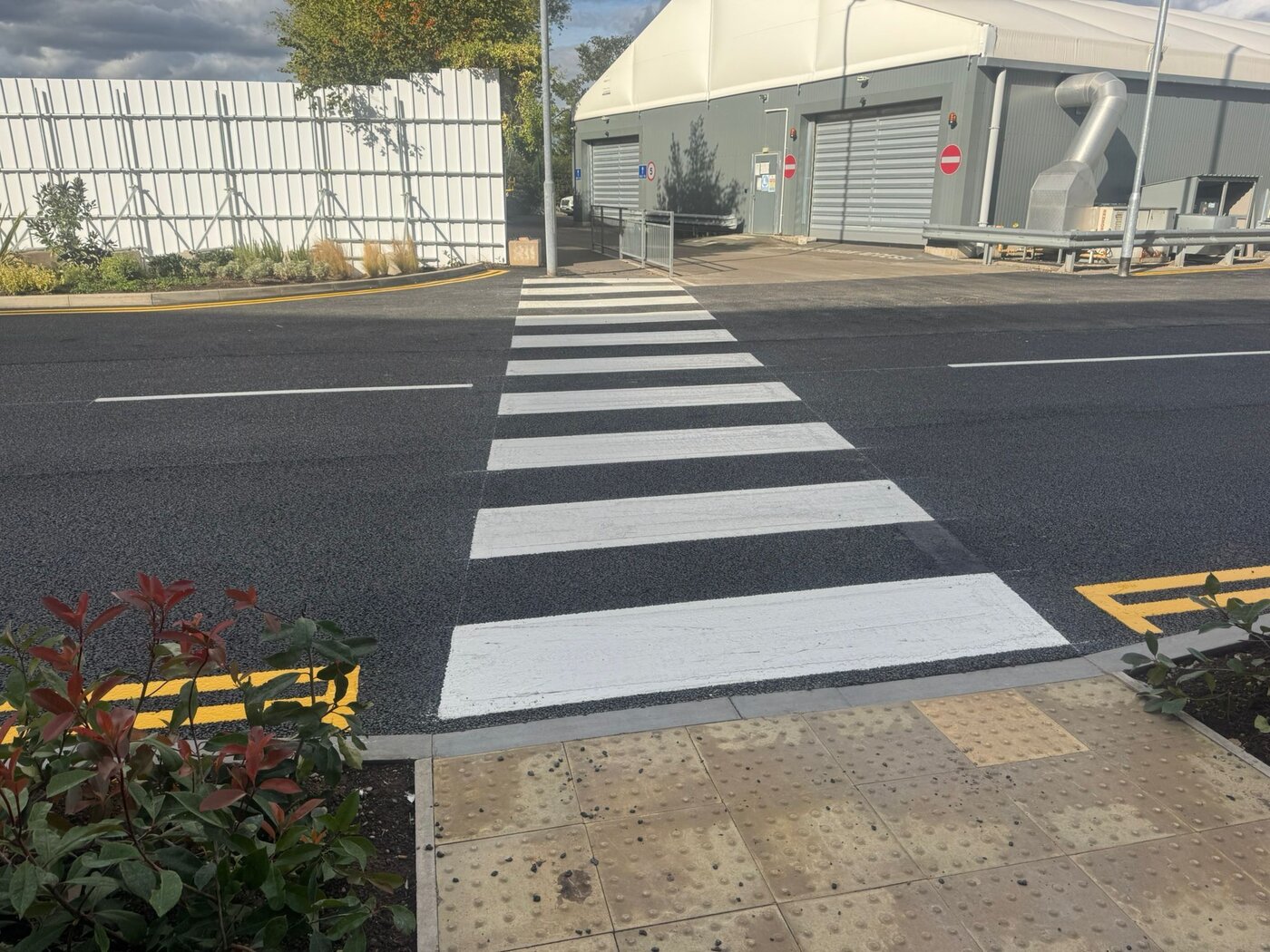 Freshly marked zebra crossing with tactile paving at an industrial site, marked by C&R