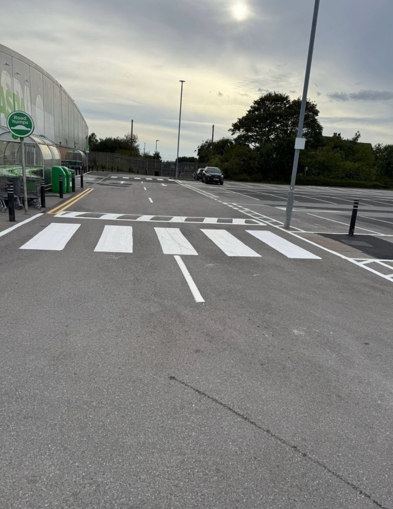 Freshly painted zebra crossing on a supermarket car park, marked by C&R