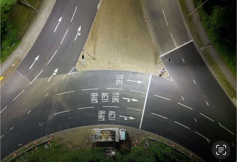 Aerial view of a freshly marked road junction with lane arrows and destination markings by C&R