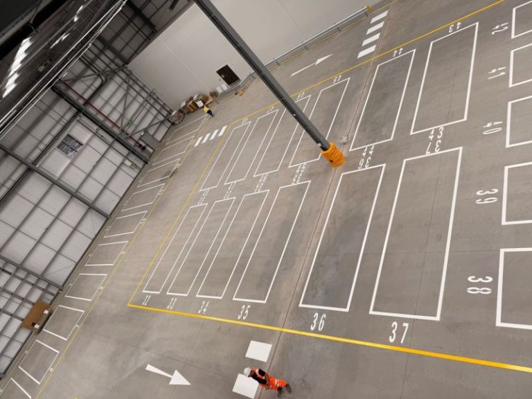 Internal warehouse line marking—numbered bays and safety lines freshly painted.